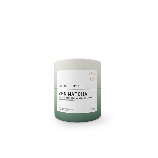 A cylindrical matcha tea tin with a matte finish, featuring a color gradient from light gray at the top to sage green at the bottom, with a white label reading 'ZEN MATCHA' and 'STORM + INDIA'.